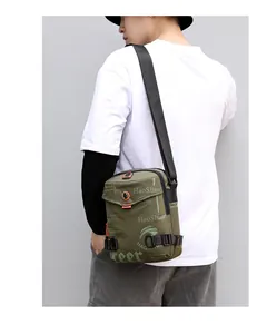 Close-up of military green waterproof crossbody bag showing multi-layer zippers and side buckle