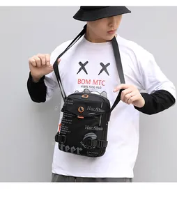 Detail of waterproof black crossbody bag with orange drawstring and street style design