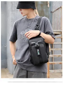 Outdoor model display of a black multifunctional men's chest bag with USB port and shiny texture