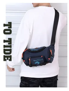 Detail of waterproof nylon waist bag in navy blue with orange zipper pulls on a model
