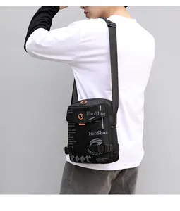 Detail of waterproof crossbody bag showing orange zipper pulls and logo on nylon fabric