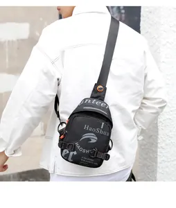 Vue détaillée du sac de poitrine multifonction noir avec des accents orange sur un modèle