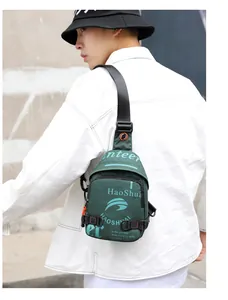 Détail du sac de poitrine en nylon vert armée avec tirette orange et sangle réglable