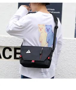Rear view of black waterproof oxford messenger bag with red webbing and adjustable strap