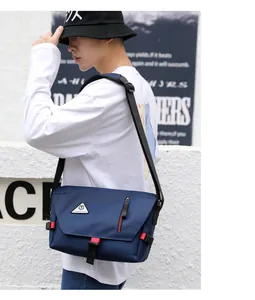 Blue canvas messenger bag with flip-top design and red-black buckle on a male model
