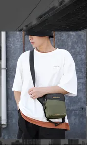 Detail of waterproof nylon crossbody bag featuring military green and black color contrast