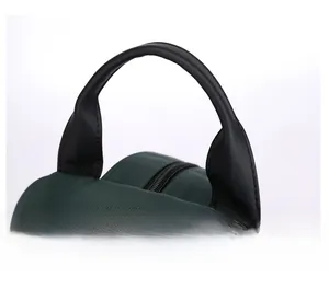 Close-up of a durable leather handle with reinforced stitching on a green nylon chest bag