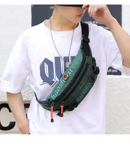Detail of dark green waterproof crossbody bag with orange zipper cords and multiple hooks