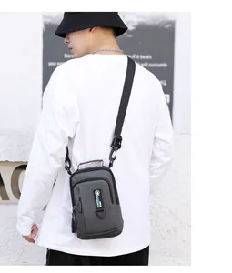 Men's waterproof dark gray crossbody chest bag shown on model in urban outdoor setting