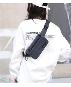 Detail of gray-blue nylon crossbody bag showing the adjustable black shoulder strap and texture