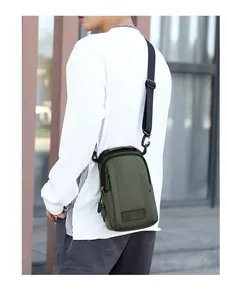 Détail du port de charge USB latéral sur un sac de poitrine en nylon imperméable vert foncé
