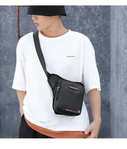 Close-up of waterproof black tactical crossbody bag with brand logo on a model