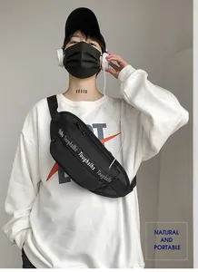 Close-up of black waterproof nylon sling bag with Toughslhs webbing strap on model