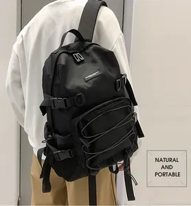 Tactical black nylon backpack detail showing side buckles and mesh pocket on model