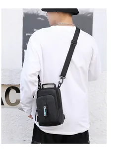 Rear side view of a black tactical crossbody chest bag worn by a male outdoors