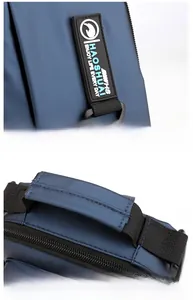 Detail of waterproof navy nylon bag showing reinforced handle and rubberized logo patch