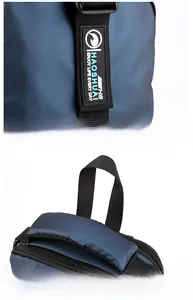 Detail view of the durable top handle and reinforced rubber logo on the blue chest bag