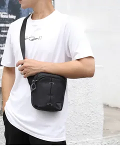 Close-up of lightweight black multi-compartment leg bag with durable zippers and labels