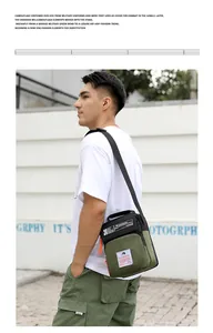 Sac bandoulière homme en nylon vert olive et noir présenté dans un décor de style plein air