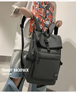 Détail d'un sac à dos gris foncé montrant le nylon durable et la fermeture à boucle