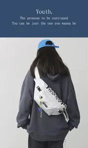 Detail van de witte crossbodytas met schaakbordpatronen en neon groene karabijnhaak