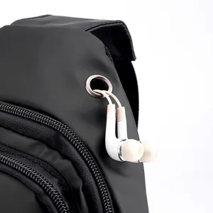 Men's black crossbody bag with integrated metal headphone port and waterproof finish