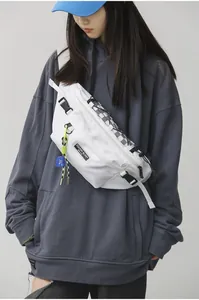 Detail van witte nylon crossbodytas met zwart-wit geruite accenten aan de rits