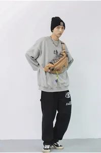 Detail van kaki borsttas met dambordpatroon en neongele hanger in streetwear stijl voor