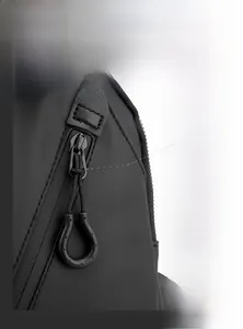 Gros plan sur les fermetures éclair en métal et le tissu en nylon d'un sac de poitrine noir