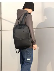 Side view of black water-resistant commuter backpack with 'We Power' text on model