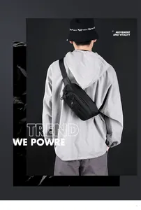 Rear view of black waterproof sports chest bag worn with grey hoodie and bucket hat