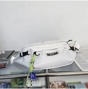 Detailopname van witte crossbodytas met neongroene band en trendy merklabels op de tas