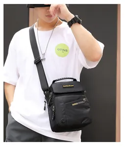 Détail du sac bandoulière en nylon imperméable avec poches zippées et poignée en caoutchouc