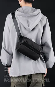 Rear view of a black waterproof nylon crossbody bag on a model in urban techwear style