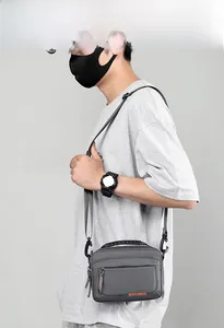 Détail du sac à bandoulière gris imperméable avec logo WEPOWER orange et poche frontale