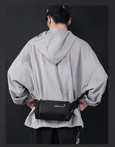 Vue arrière du mannequin portant un sac banane noir en nylon sur un sweat gris
