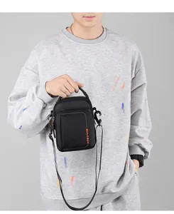 Detail of black waterproof crossbody bag with orange WEPOWER logo and nylon texture