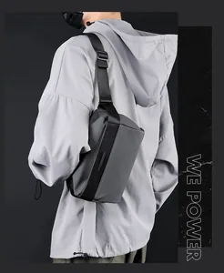 Detail view of dark grey functional crossbody bag with matte finish on male model
