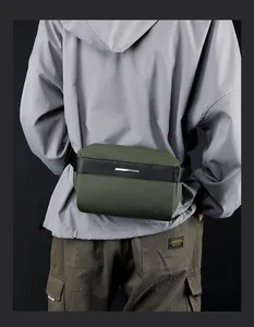 Detail of waterproof army green crossbody bag with metallic logo and nylon texture