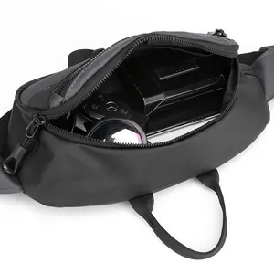 Waterproof black tactical waist bag showing spacious interior with keys and essentials