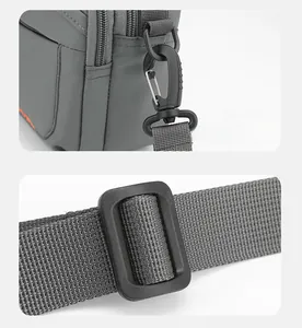 Détails de la boucle de bandoulière amovible et du curseur réglable sur le sac en nylon gris