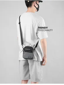 Detail showing a trendy men's grey crossbody bag with adjustable black shoulder strap