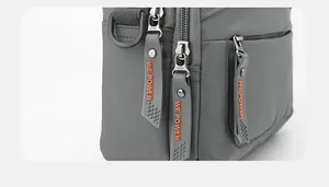 Détail des fermetures éclair SBS avec tirettes WE POWER sur un sac gris décontracté