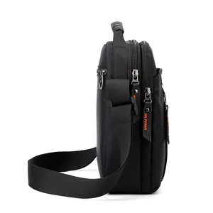 Bandolera de nailon negro para hombre con detalle de cremallera naranja y diseño multicapa