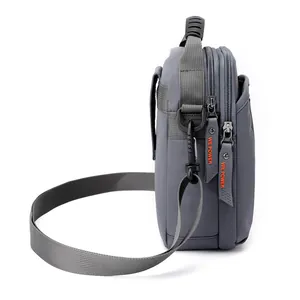 Grey multipurpose men's crossbody bag with multi-layer zippers and orange pull tabs