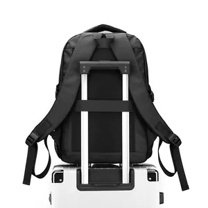 Sac à dos business noir avec sangle de bagage fixé sur la poignée d'une valise blanche