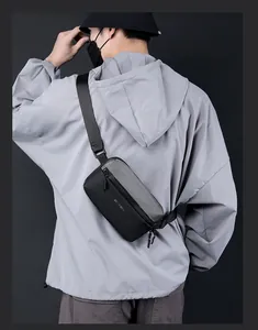 Detail of a black and grey crossbody chest bag with WE POWER text and adjustable strap