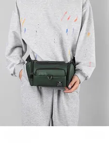 Détail d'un sac banane en nylon vert avec plusieurs poches et sangle réglable