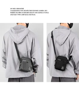 Detail view of compact nylon crossbody bags in grey and black with multi-pocket design