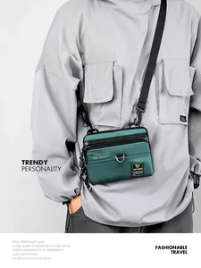 Detail of army green nylon crossbody bag with black zippers and durable metal D-ring